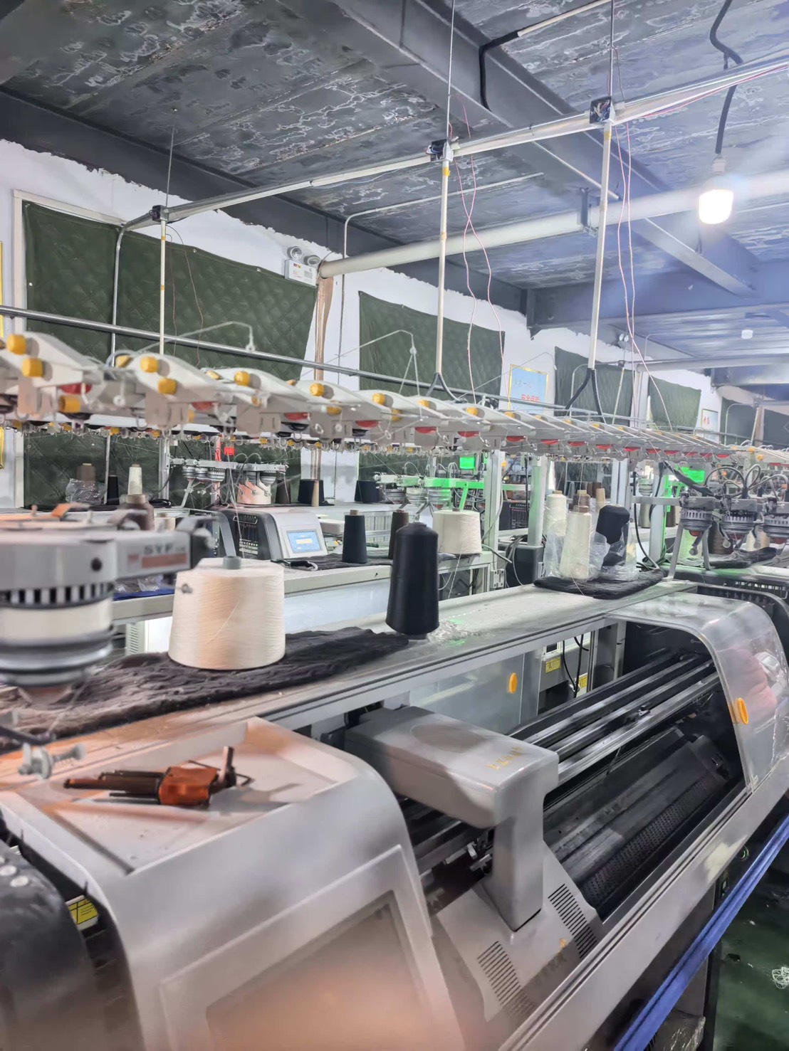 ずらりと並ぶ横編み機 — 東和盛泰の自社編立工場